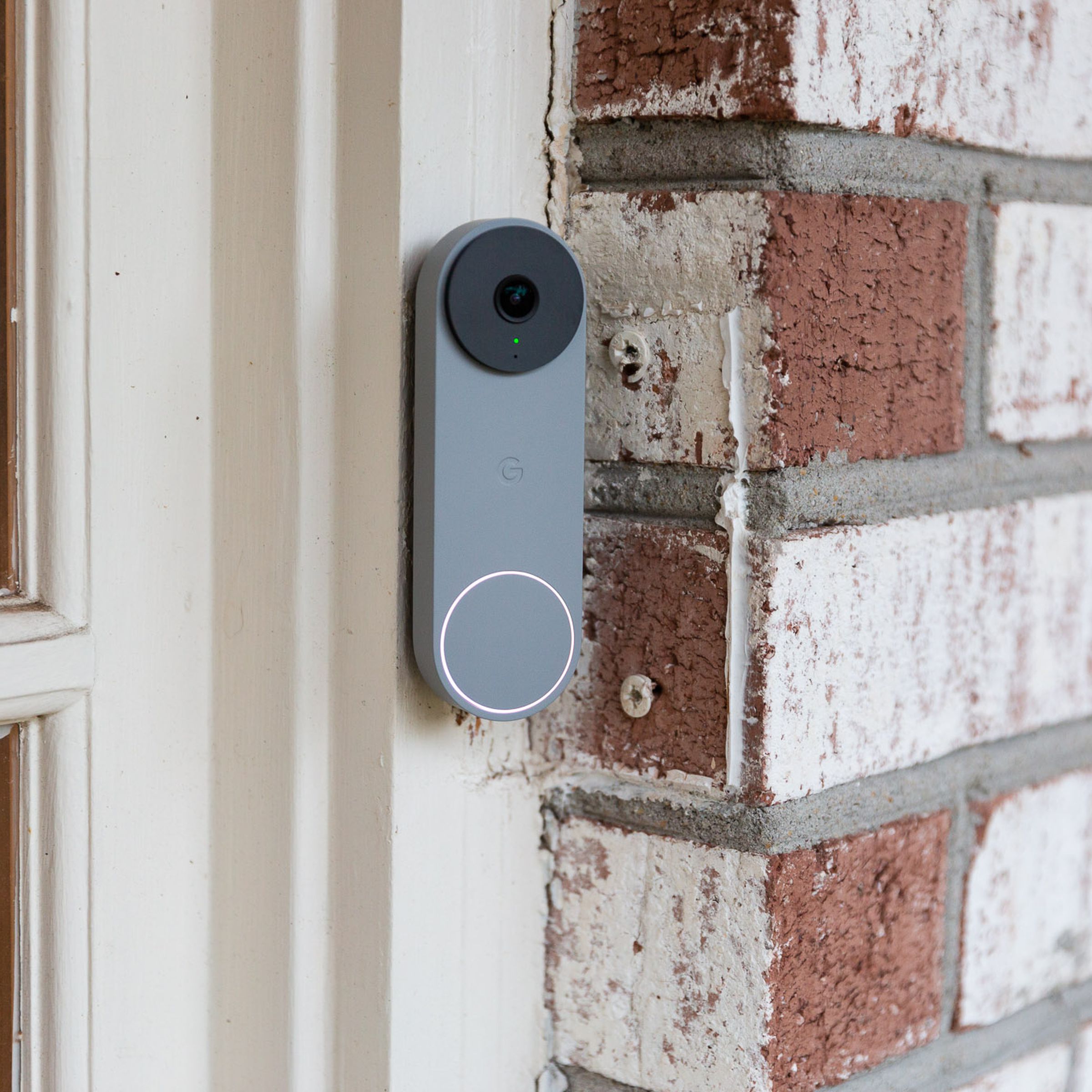 A gray Nest Doorbell on a brick wall