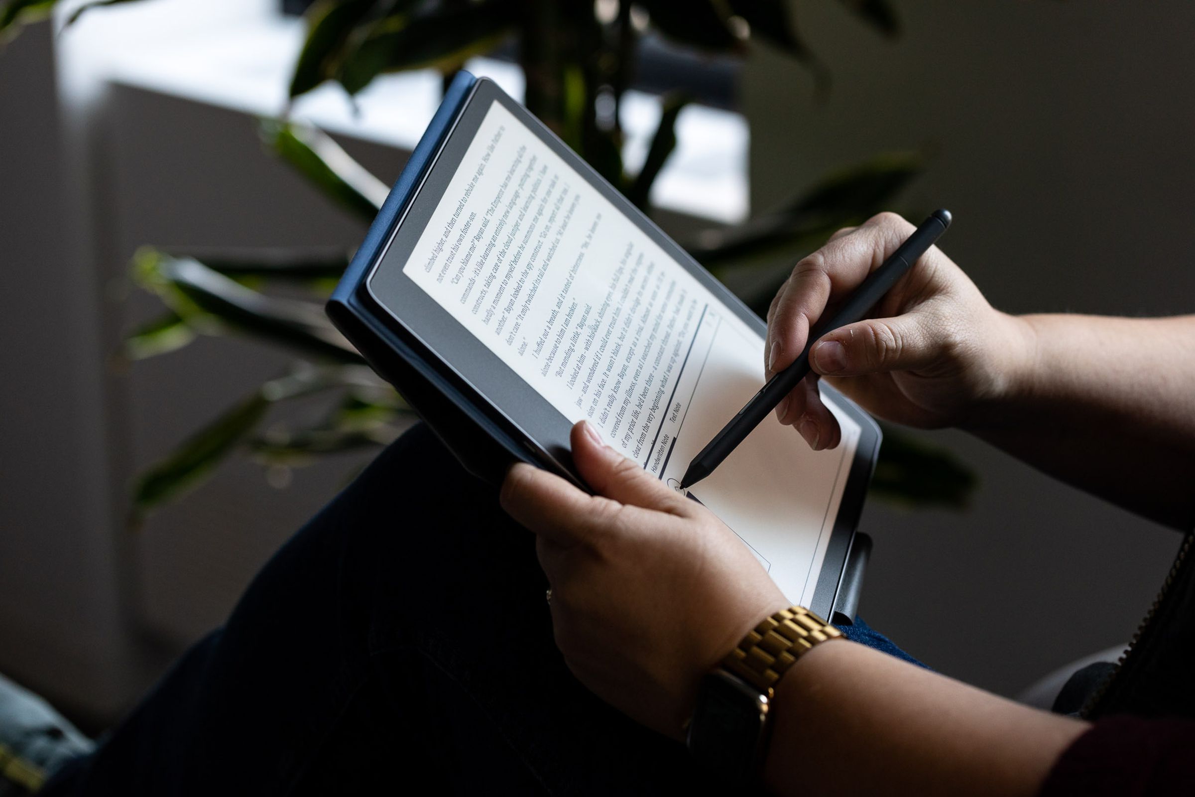 A person holding an Amazon Kindle Scribe.