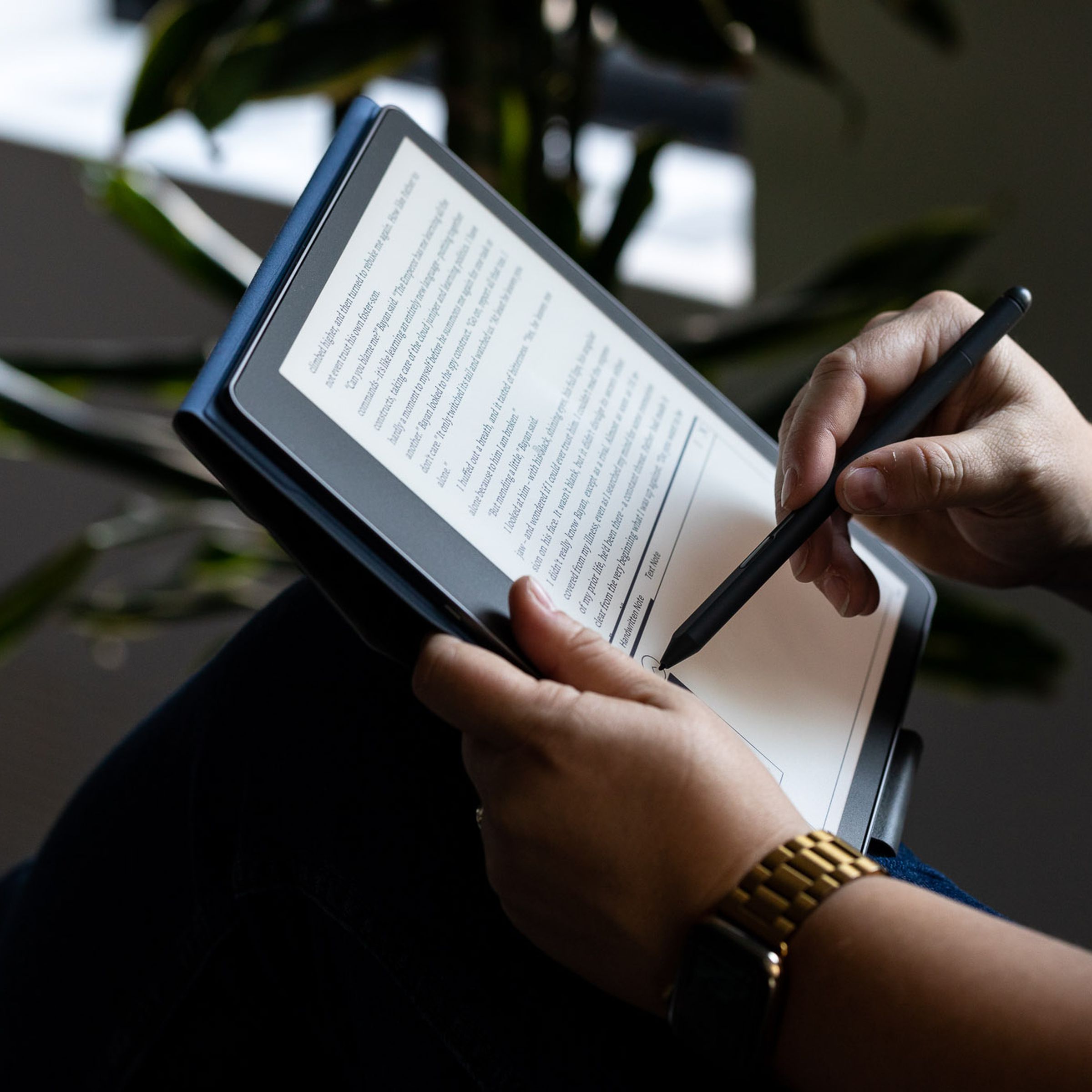 A person holding an Amazon Kindle Scribe.