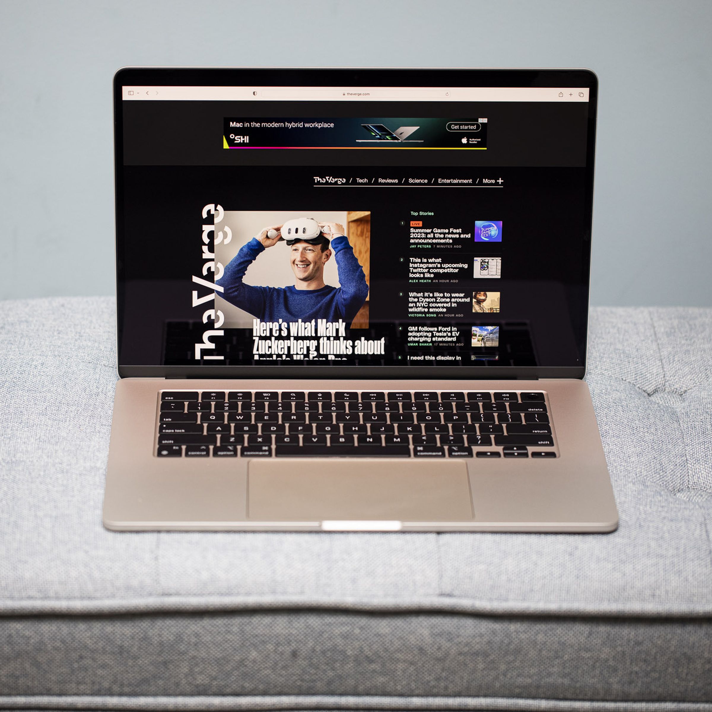 A 15-inch MacBook Air open on a gray couch.