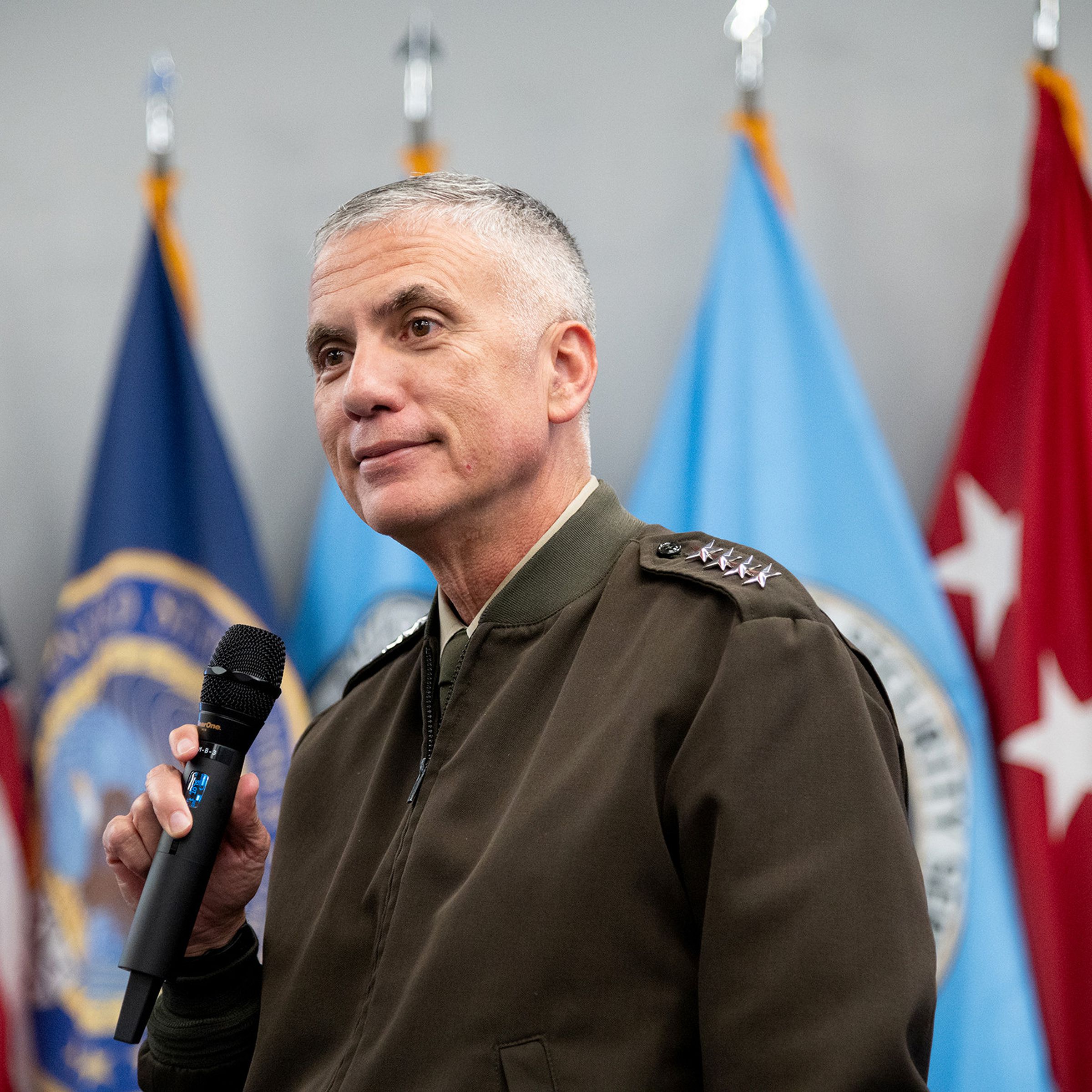 A photo of General Paul Nakasone with a microphone in hand.