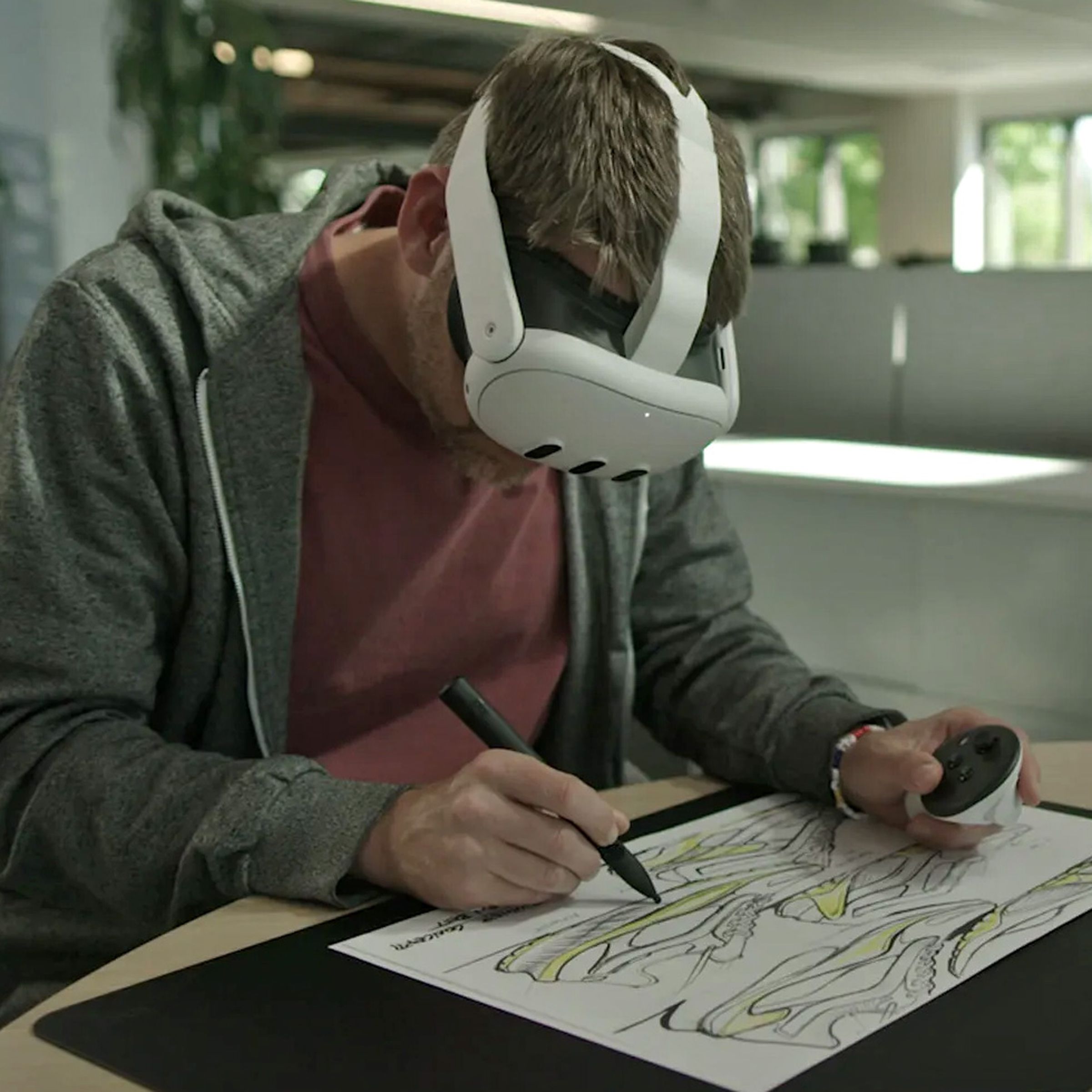 An artist wearing a Meta Quest 3 headset traces an image using the Logitech MX Ink stylus.