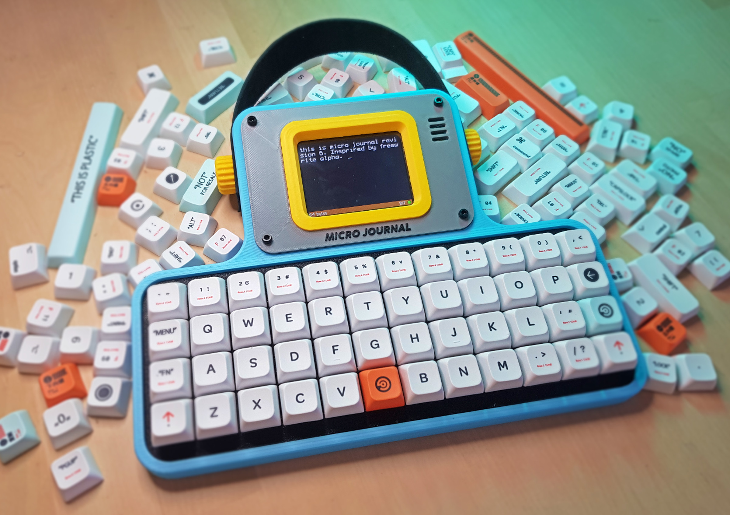 Un Kyu Lee’s Micro Journal Rev.6 sitting on a wooden table surrounded by keycaps.