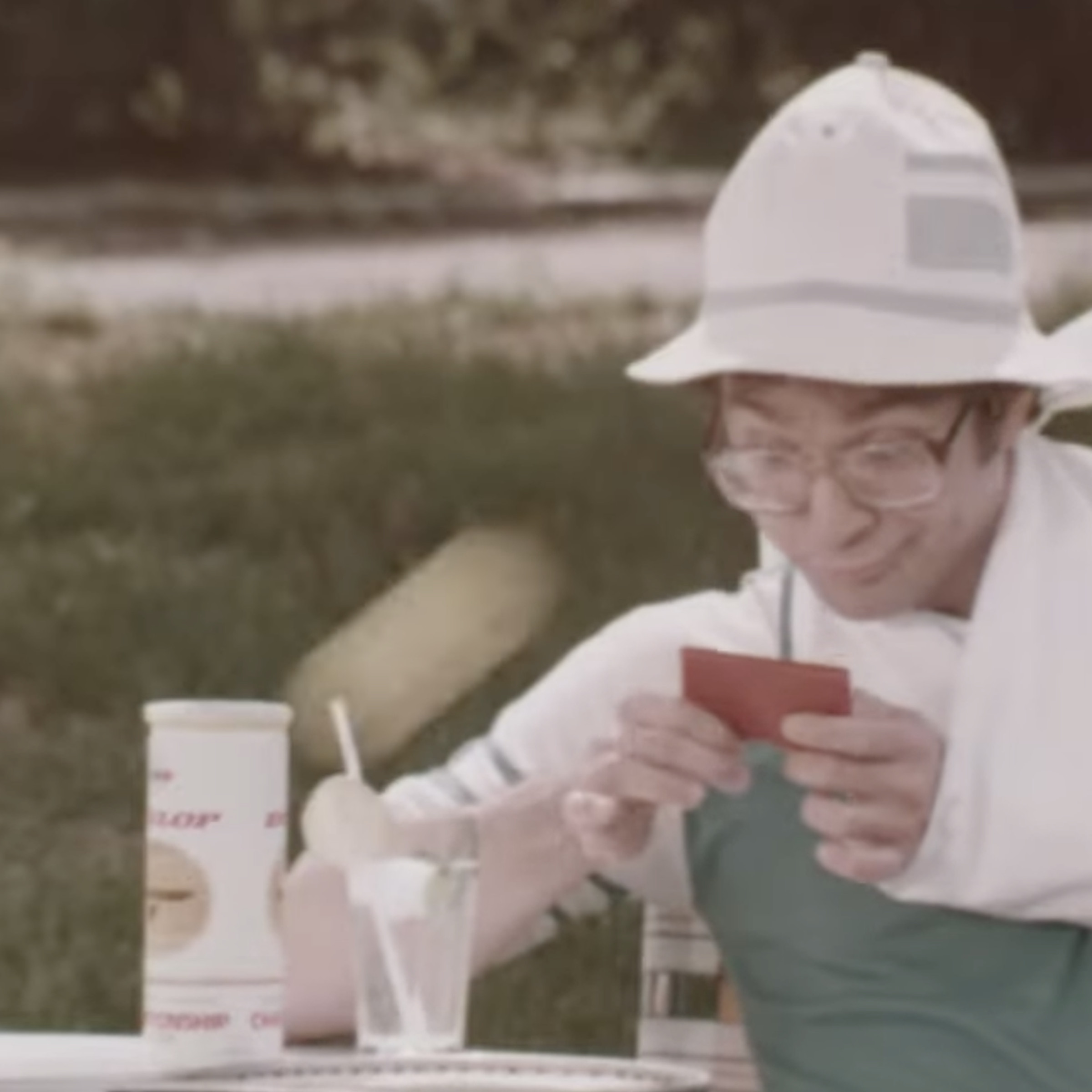 Picture of a person with an arm in a sling playing the game while sitting at a table.